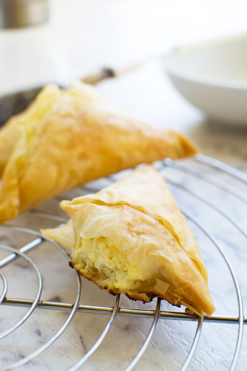 Tiropita or mini Greek cheese pies on a cooling rack