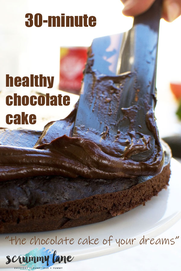 A spatula spreading avocado frosting onto a healthy chocolate cake