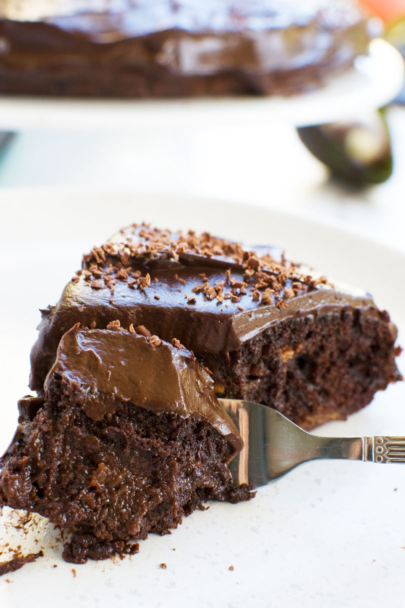 Closeup of a fork cutting into a piece of 30 minute healthy chocolate cake on a white plate and background