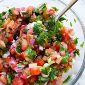 closeup of a bowl of 10 minute tomato salsa from above with a spoon in it