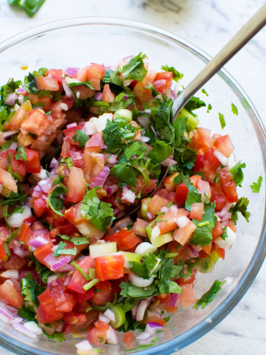 closeup of a bowl of 10 minute tomato salsa from above with a spoon in it