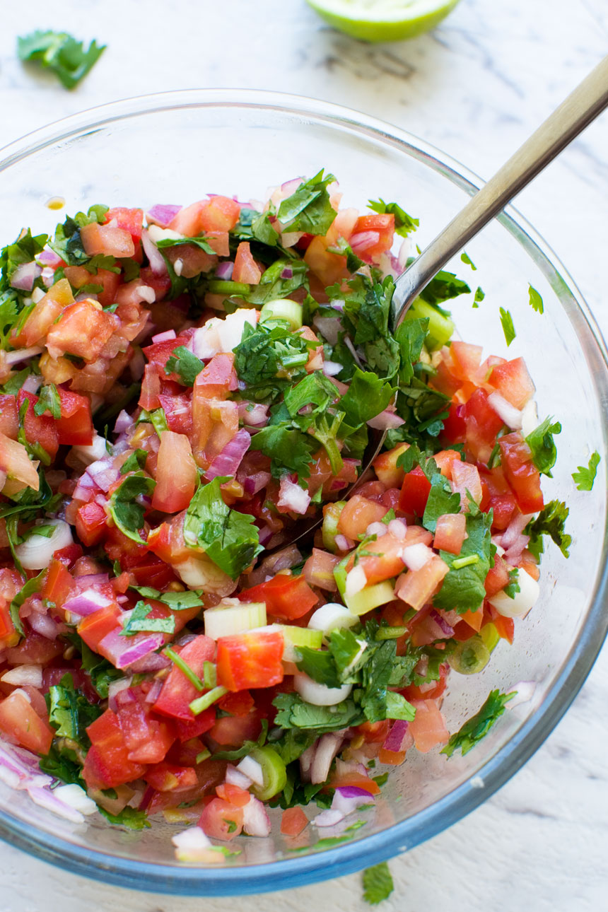 closeup of a bowl of 10 minute tomato salsa from above with a spoon in it