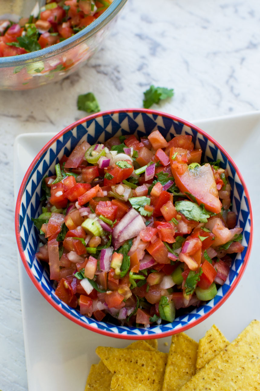 bowl of 10 minute tomato salsa on a square white plate and marble background
