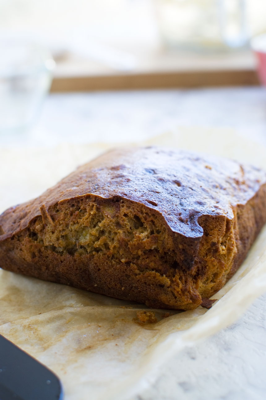 A close up of a mini banana bread just out of the oven on baking paper