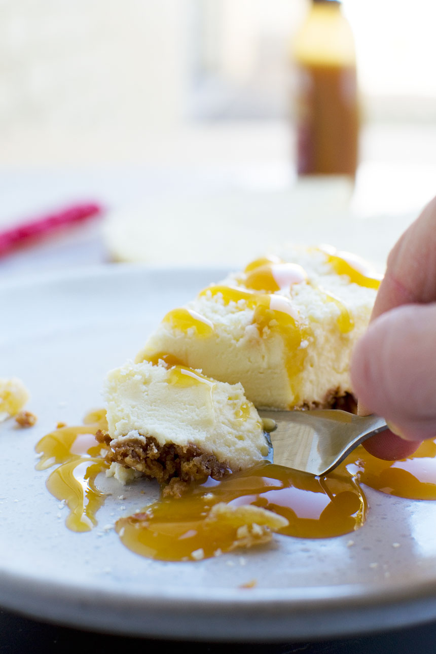 Closeup of someone eating a slice of ginger and white chocolate cheesecake with a fork