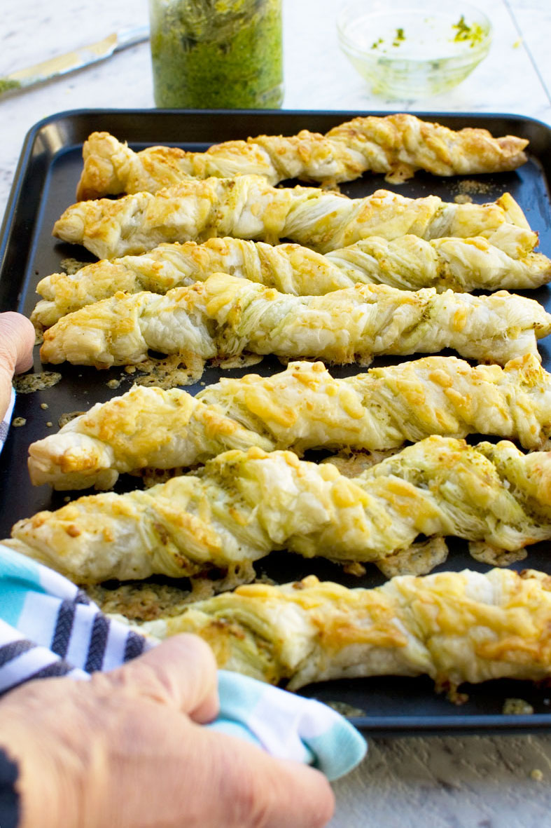 Supermarket copycat pesto and cheese twists side by side on a baking tray