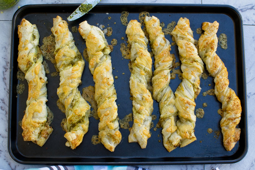 Supermarket copycat pesto and cheese twists close up on a baking tray