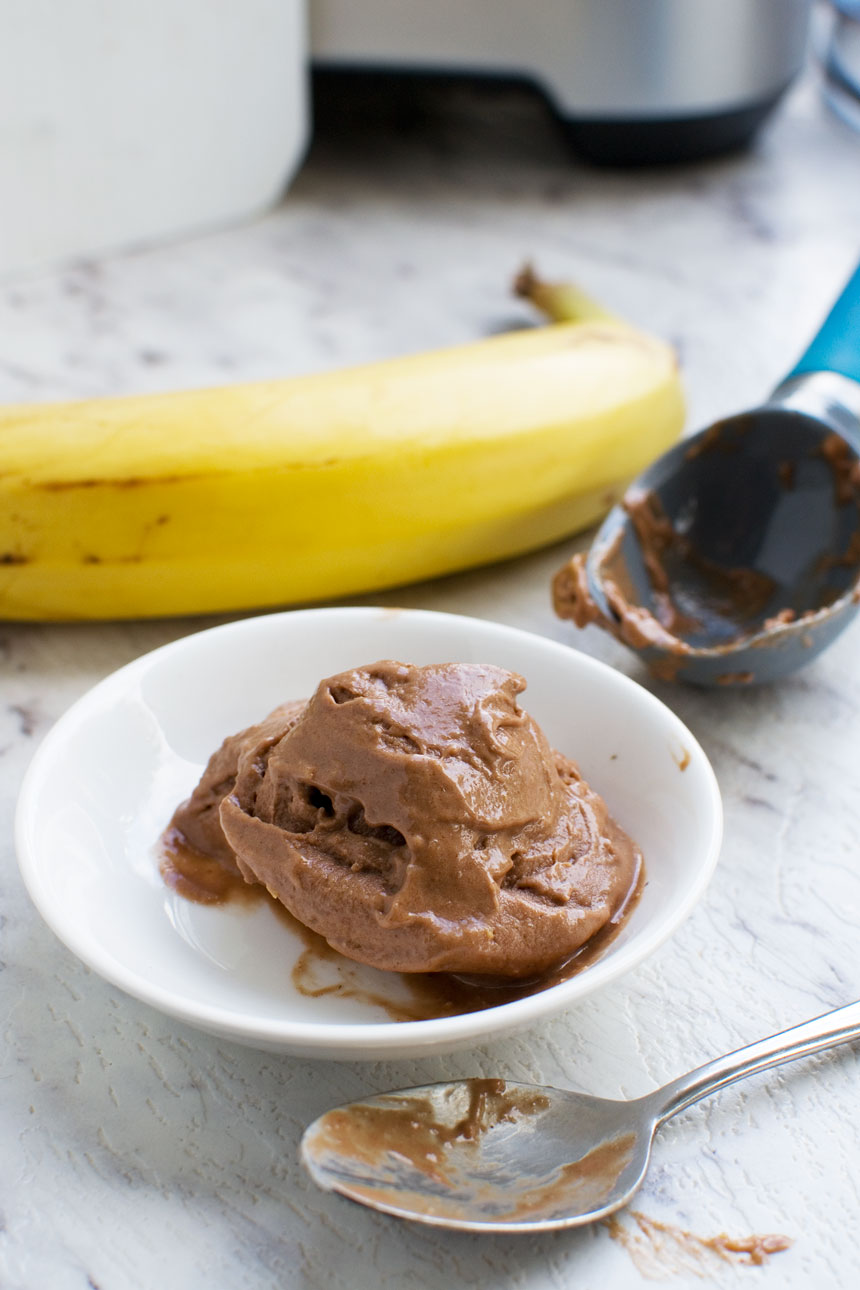 5-minute chocolate banana ice cream with a spoon with a banana and ice cream scoop in the background