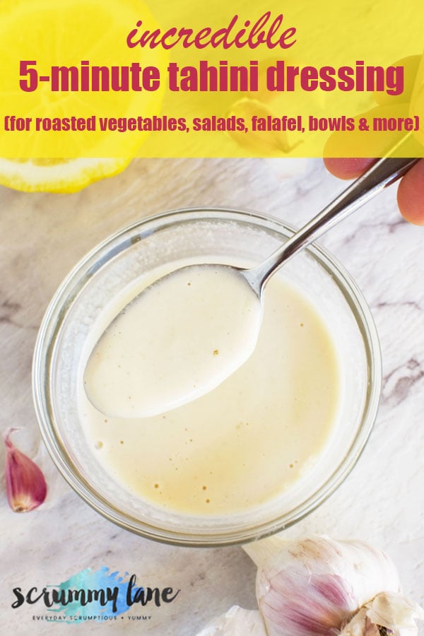 A spoon being held over a small bowl of tahini dressing for Pinterest
