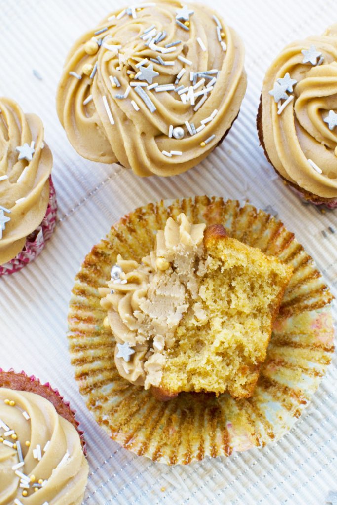 Half a gingerbread muffin with salted caramel icing on its side, with others around it