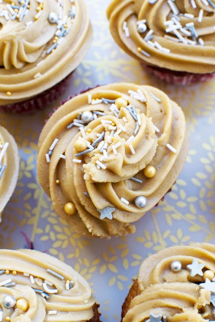 A top view of some gingerbread muffins with salted caramel icing on a decorative plate