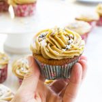 Someone holding up a gingerbread muffin with salted caramel icing