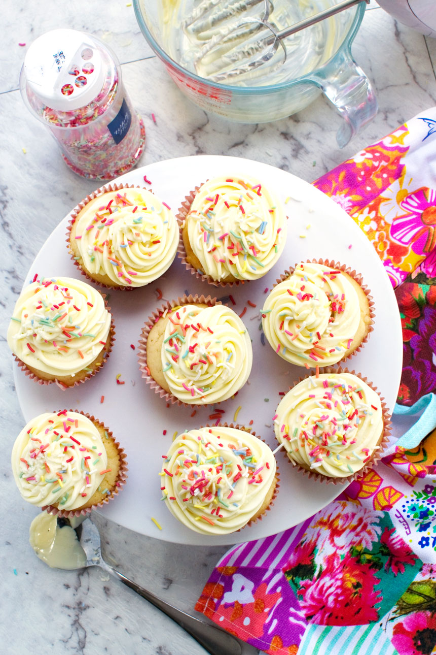 An overhead view of a plate of healthier vanilla cupcakes with a 2-ingredient frosting