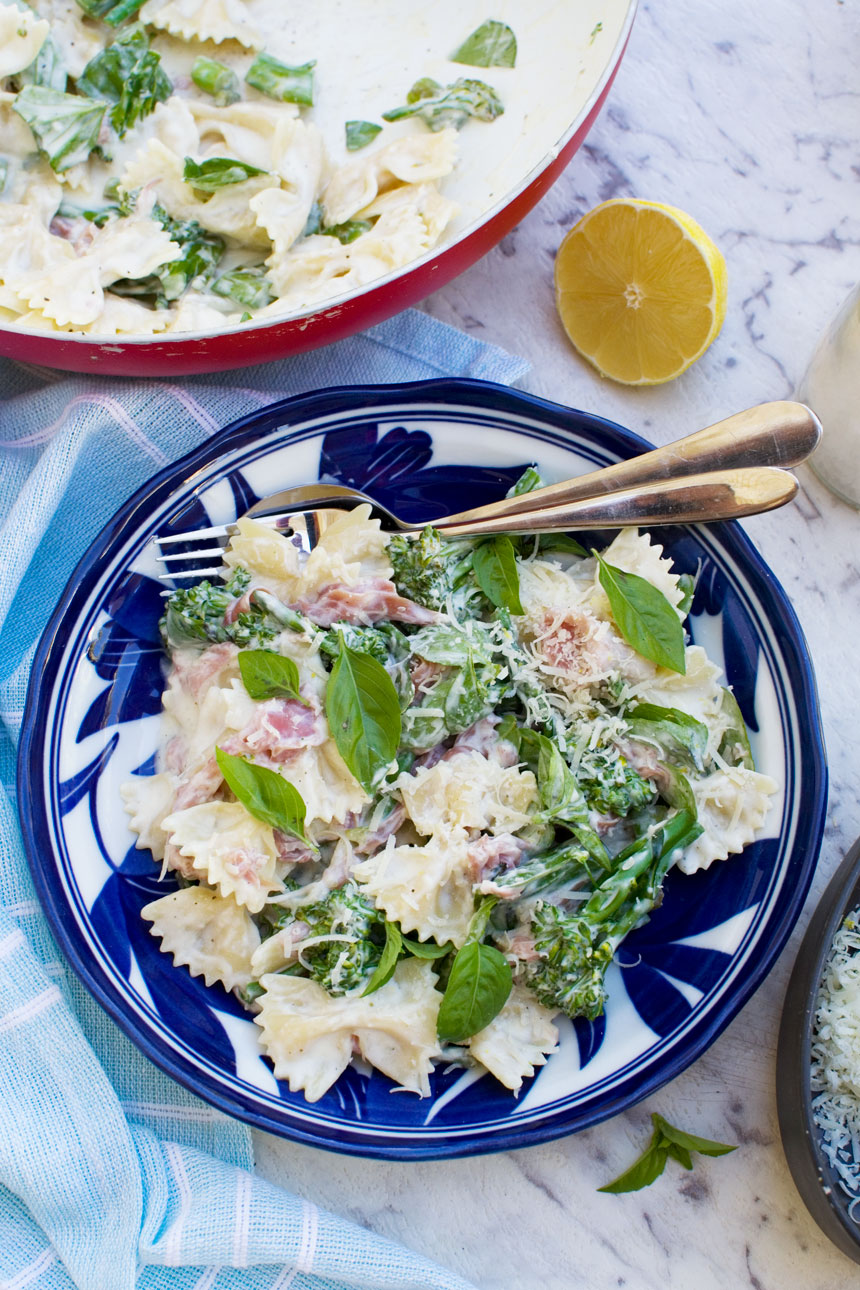 A plate of lemon ricotta pasta with broccoli and prosciutto from above