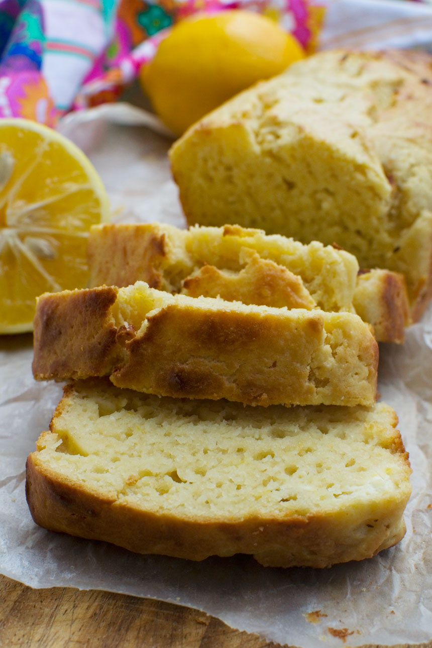 Slices of a ricotta lemon loaf cake on a wooden cutting board