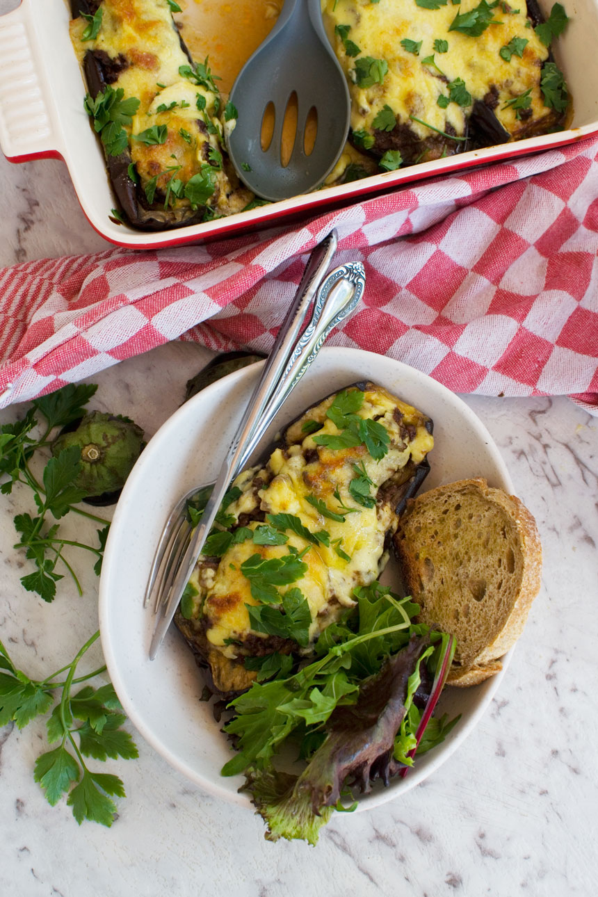 A dish of Greek stuffed eggplant from above with more in a baking dish in the background