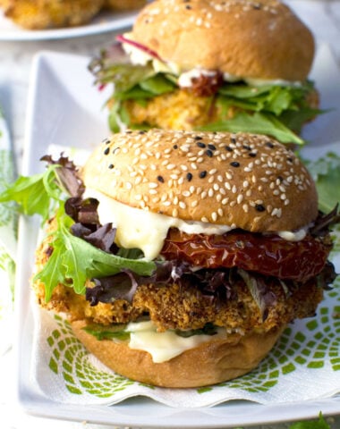 Two crispy chicken burgers on a white plate