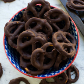 A bowl of chocolate covered pretzels or easy chocolate biscuits in a bowl on a marble background