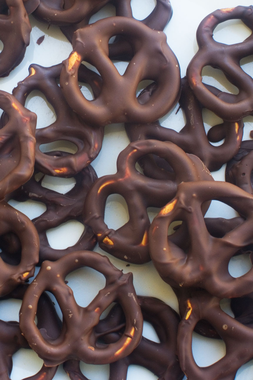 Chocolate pretzels from above piled on top of each other on a baking tray