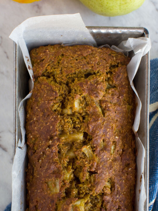 A healthy pumpkin and pear loaf cake in a loaf tin from above