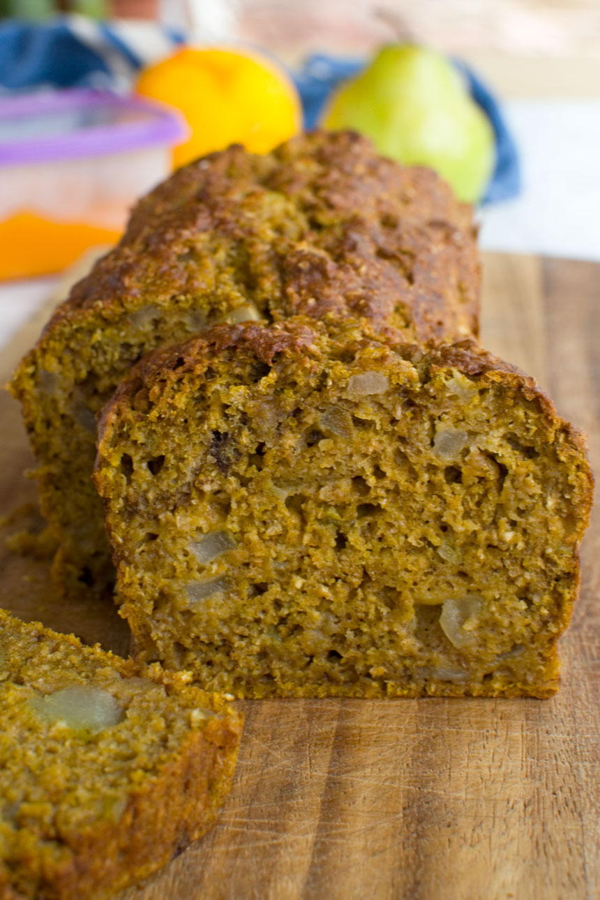 A healthy pumpkin pear loaf cake with a slice standing up at the front