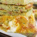 A close up of a stack of zucchini slice on a baking tray