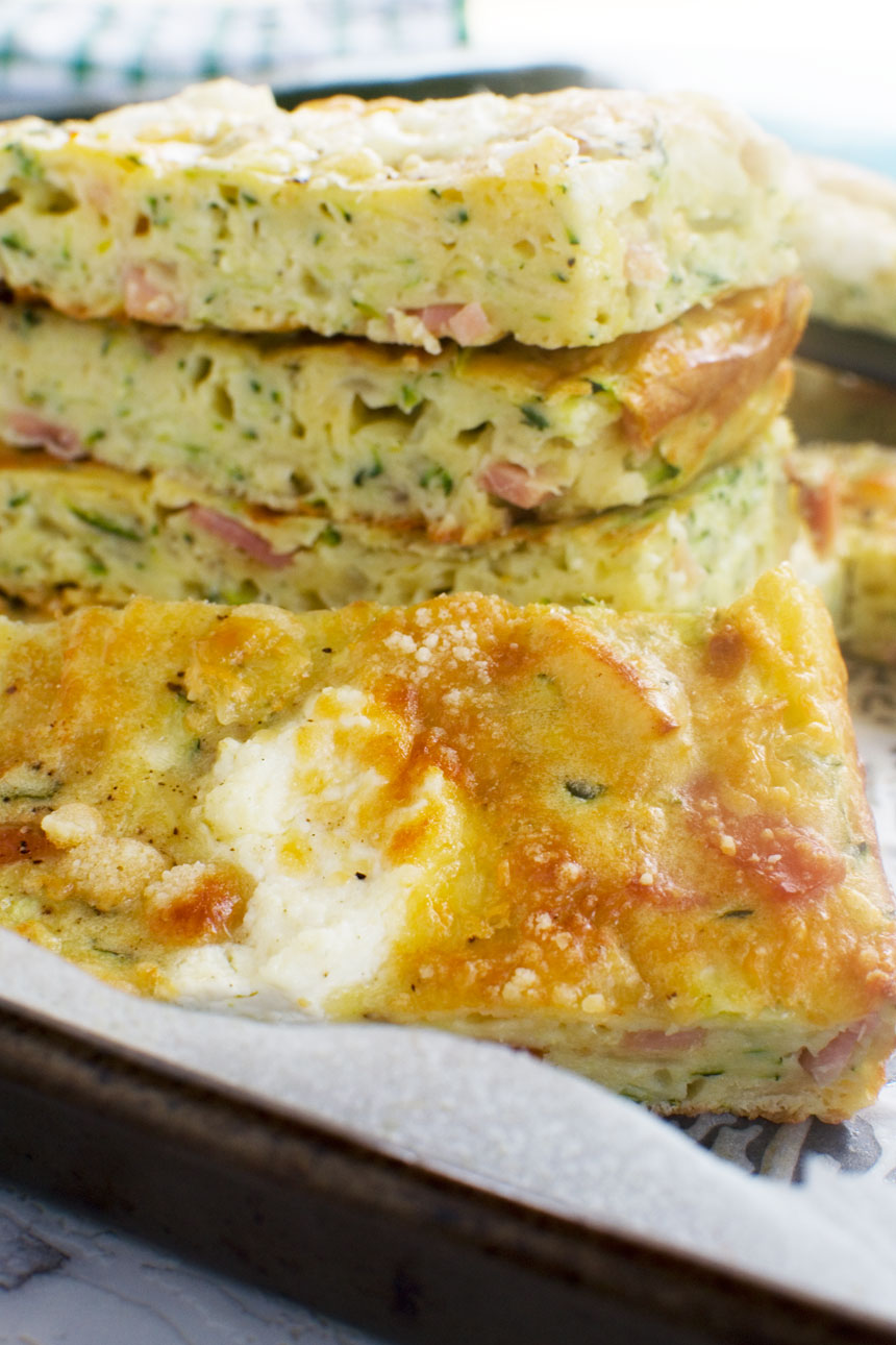 A close up of a stack of zucchini slice on a baking tray