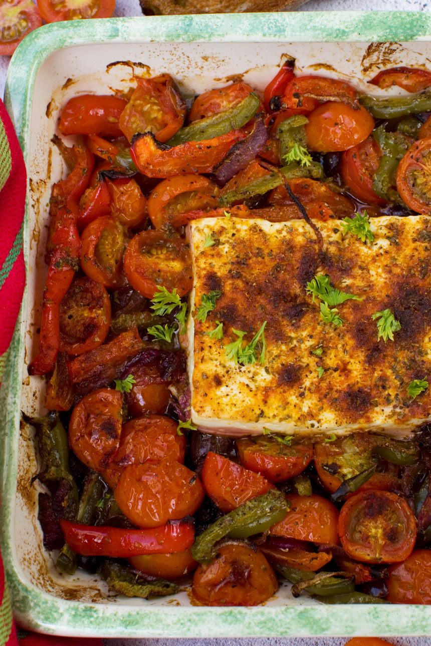 A dish of baked feta with tomatoes, peppers and olives taken from above