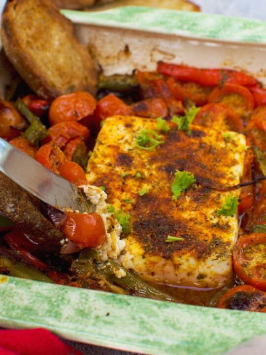 A dish of baked feta with tomatoes, feta and olives