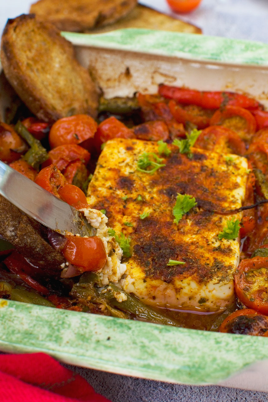 A dish of baked feta with tomatoes, feta and olives