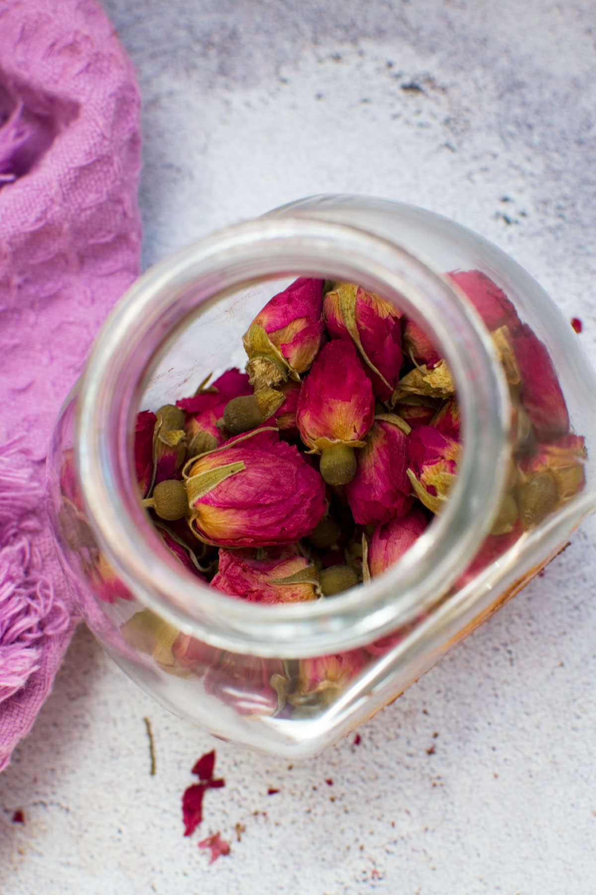 A small jar of edible rose petals from above with the lid off
