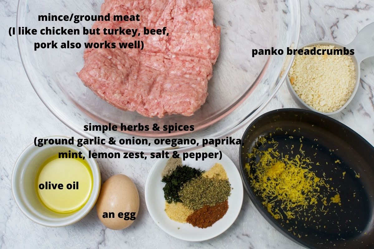 Labelled ingredients for making air fryer Greek meatballs or chicken keftedes: ground chicken, panko breadcrumbs, olive oil, an egg, herbs and spices and lemon zest