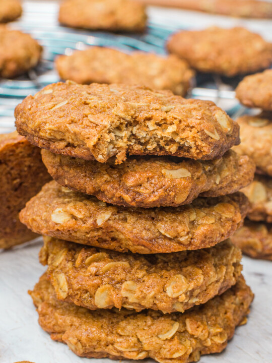 A closeup of a stack of Anzacc biscuits with more behind