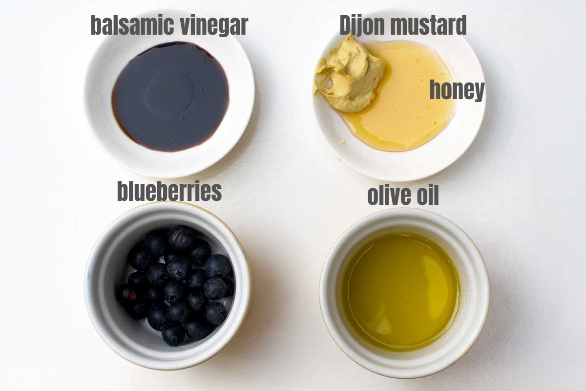 5 labelled ingredients for making blueberry dressing: balsamic vinegar, Dijon mustard, honey, blueberries and olive oil