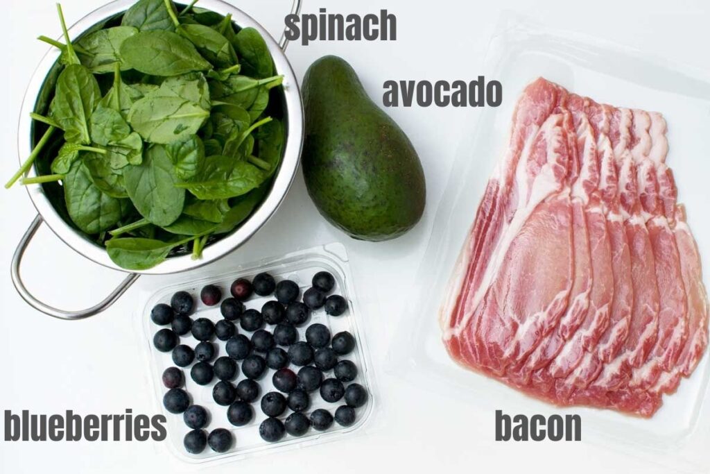 The 4 ingredients to make a spinach avocado salad with bacon and blueberries