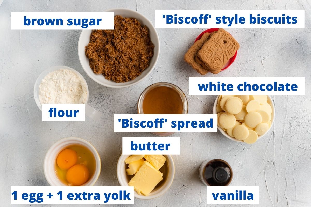 All the ingredients needed to make Biscoff blondies, labelled including brown sugar, Biscoff biscuits, flour, white chocolate, Biscoff spread, butter, eggs and vanilla