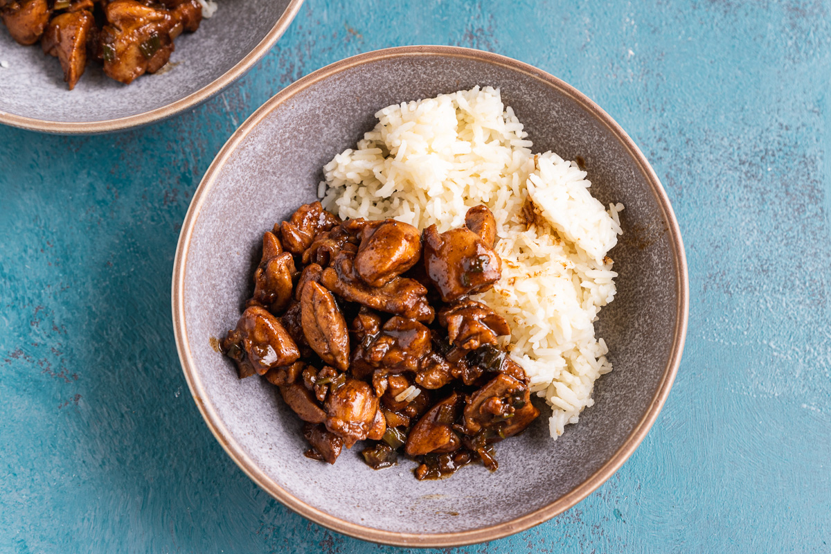 A dish of Shanghai chicken and rice from above on a blue background