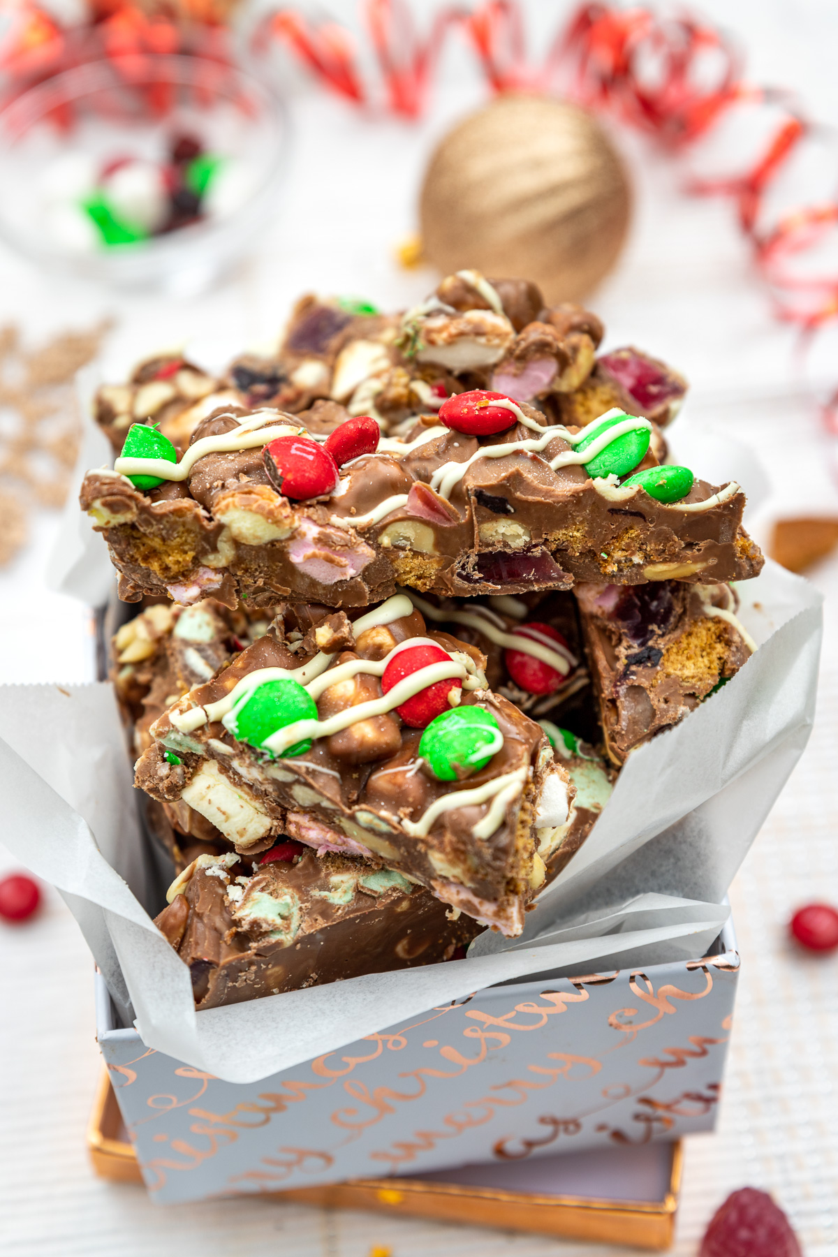 Christmas rocky road in a white and gold box with Christmas decorations behind