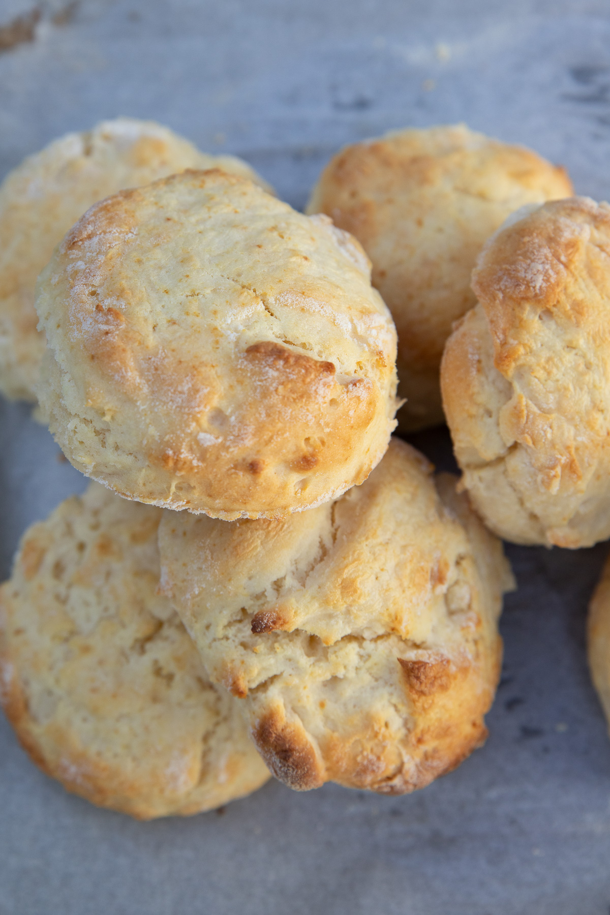 Overhead view of a closeup of a small pile of baked lemonade scones on baking paper.