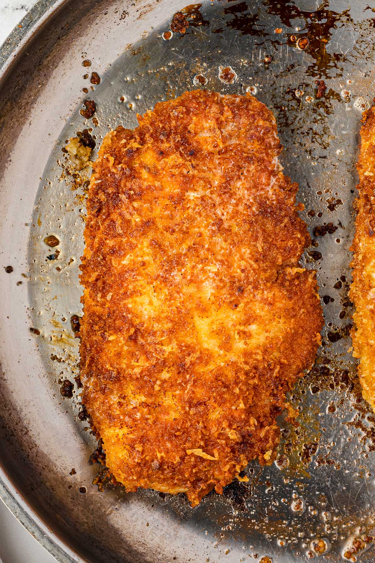 An overhead closeup view of crispy panko chicken cooked in a pan.