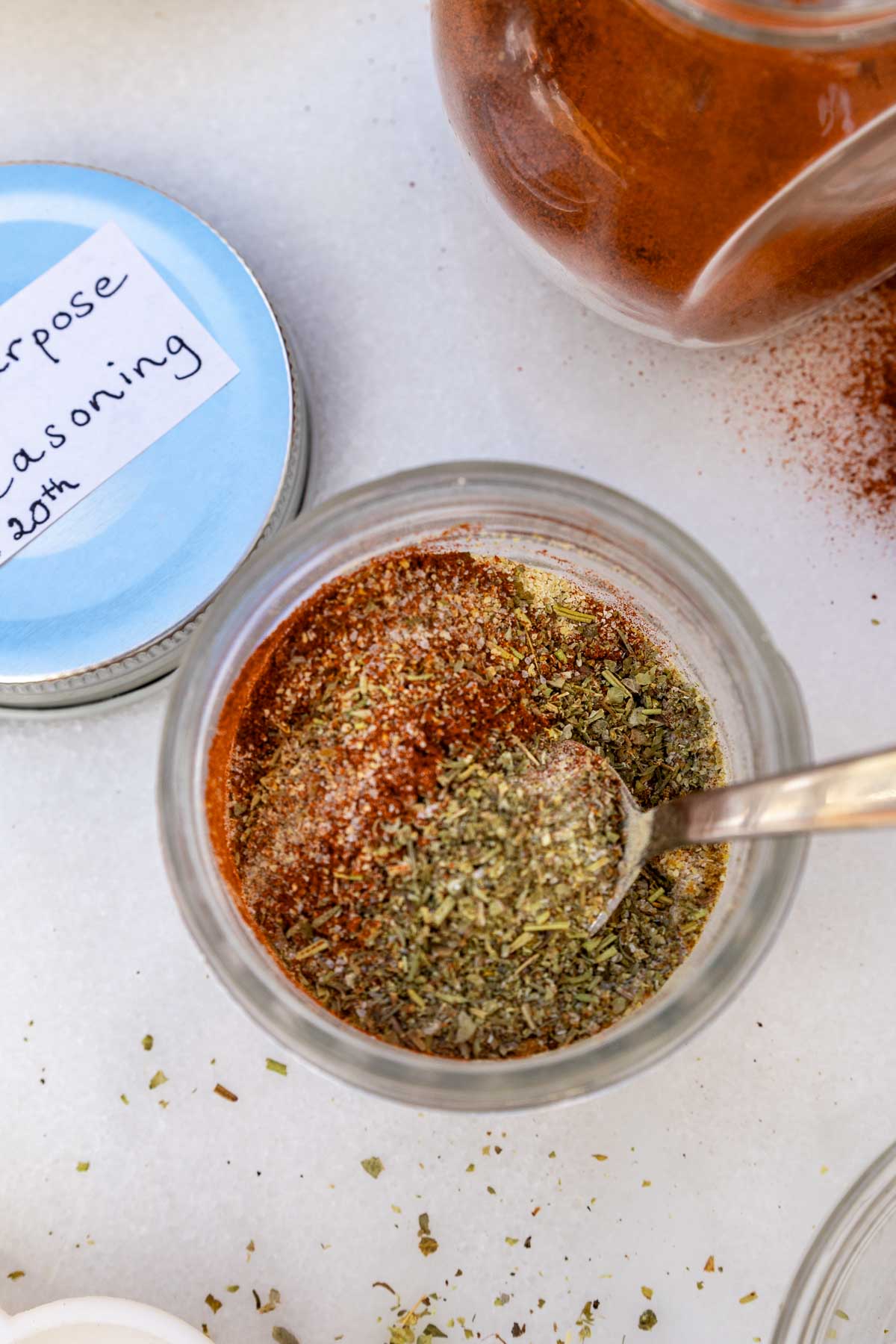 Overhead shot of all-purpose seasoning in an ornate glass jar with labelled lid at the side.