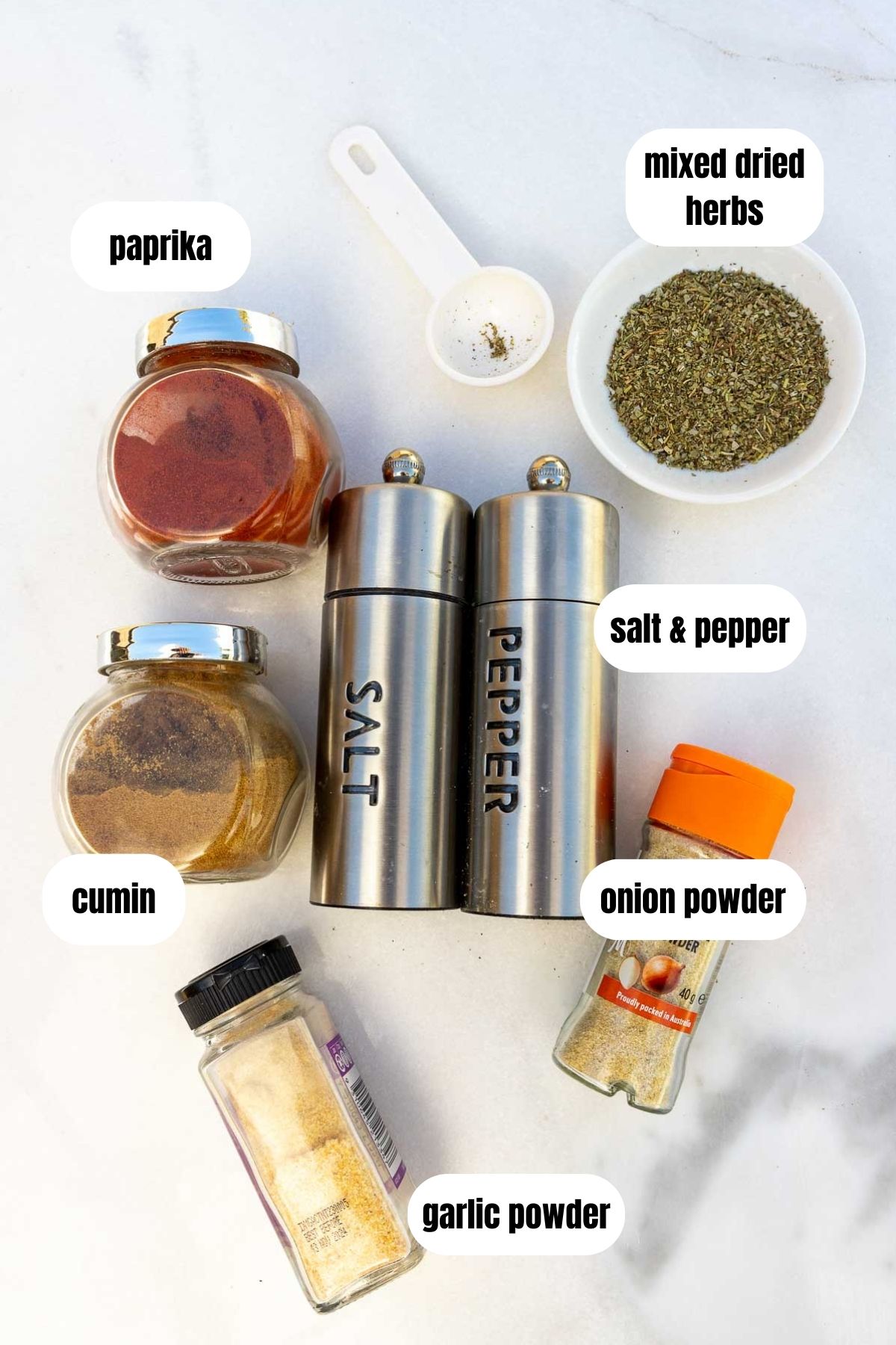 All the ingredients needed to make an all-purpose seasoning including paprika, mixed dried herbs, salt and pepper, cumin, garlic powder and onion powder.