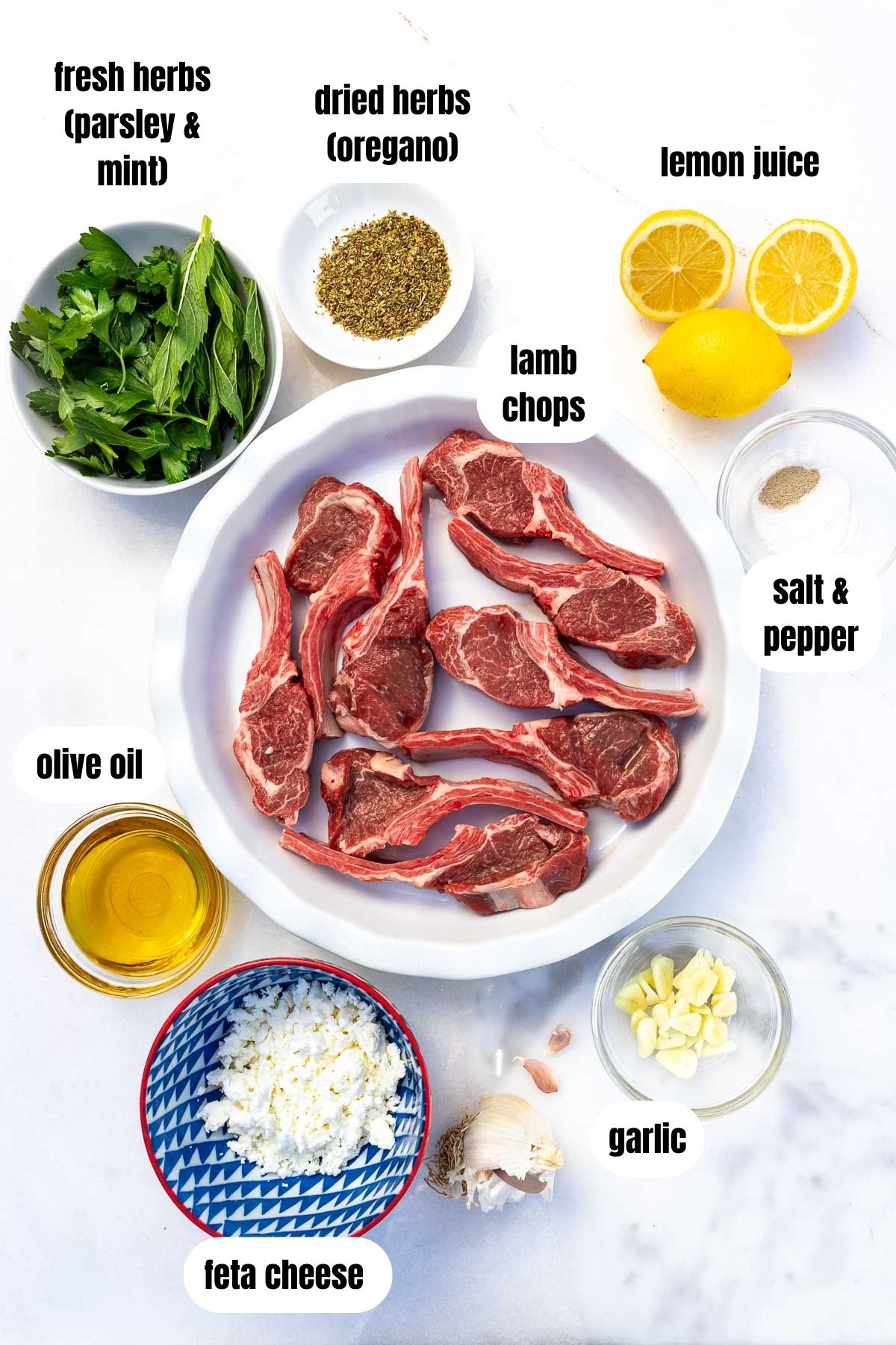 A collage of all the ingredients needed to make Greek style oven baked lamb chops, labelled, including lean lamb chops, garlic, olive oil, lemons, dried oregano, salt and pepper, fresh herbs, and crumbled feta cheese.