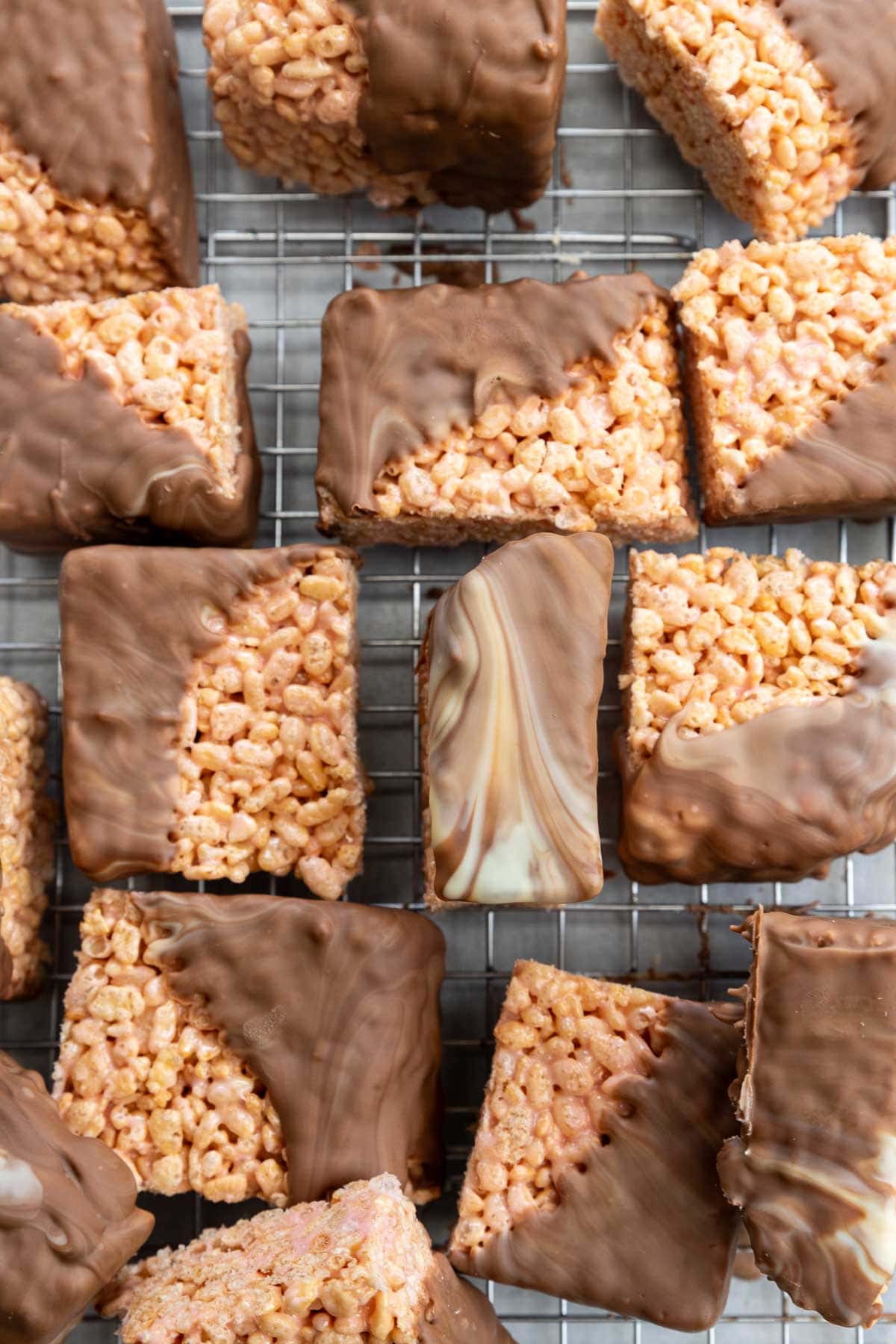 Overhead view of the bars half dipped in swirled white and milk chocolate, all on a cooling rack.