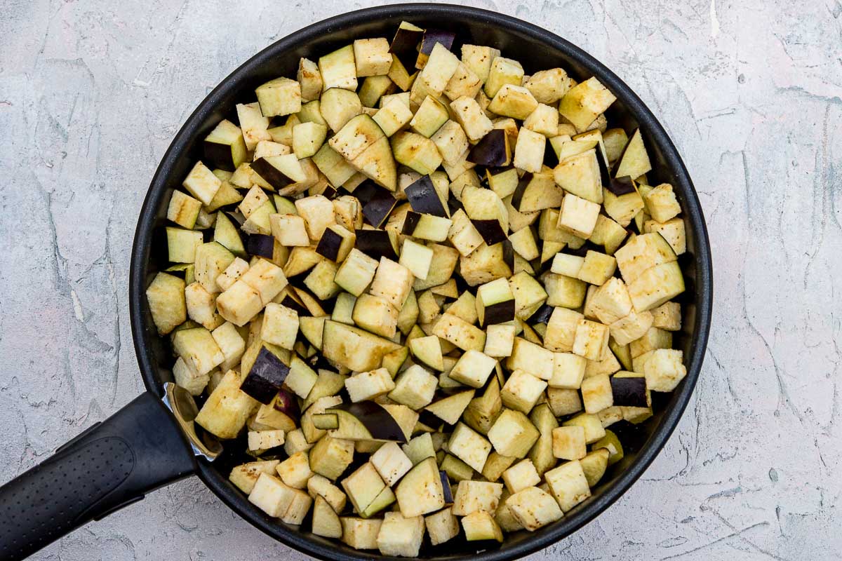 Diced eggplant in a frying pan.