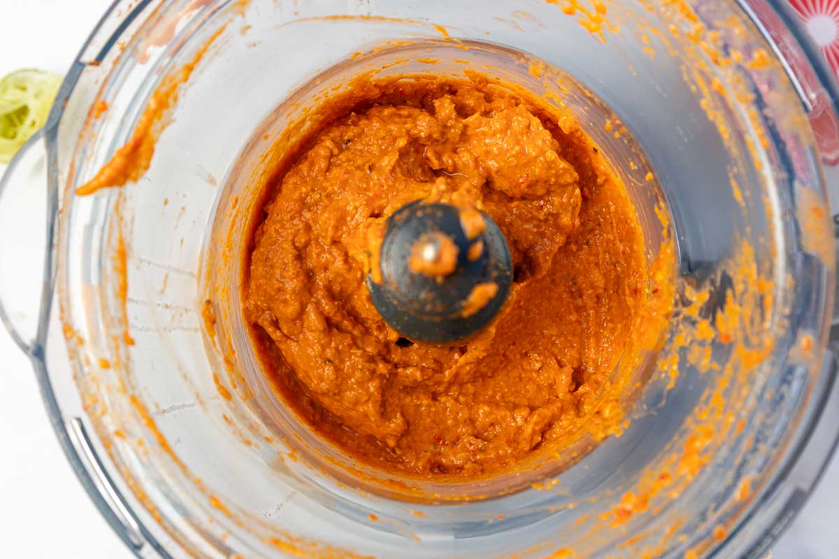 An overhead view of just-blended romesco sauce in a small food processor.
