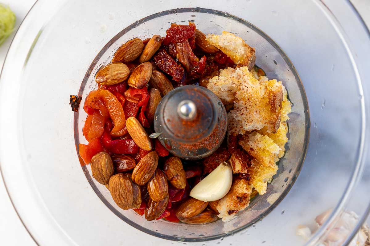 All the ingredients needed to make romesco sauce for fish in a food processor.