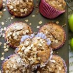 Overhead view of the muffins with oats sprinkled over the top and still in the muffin pan.