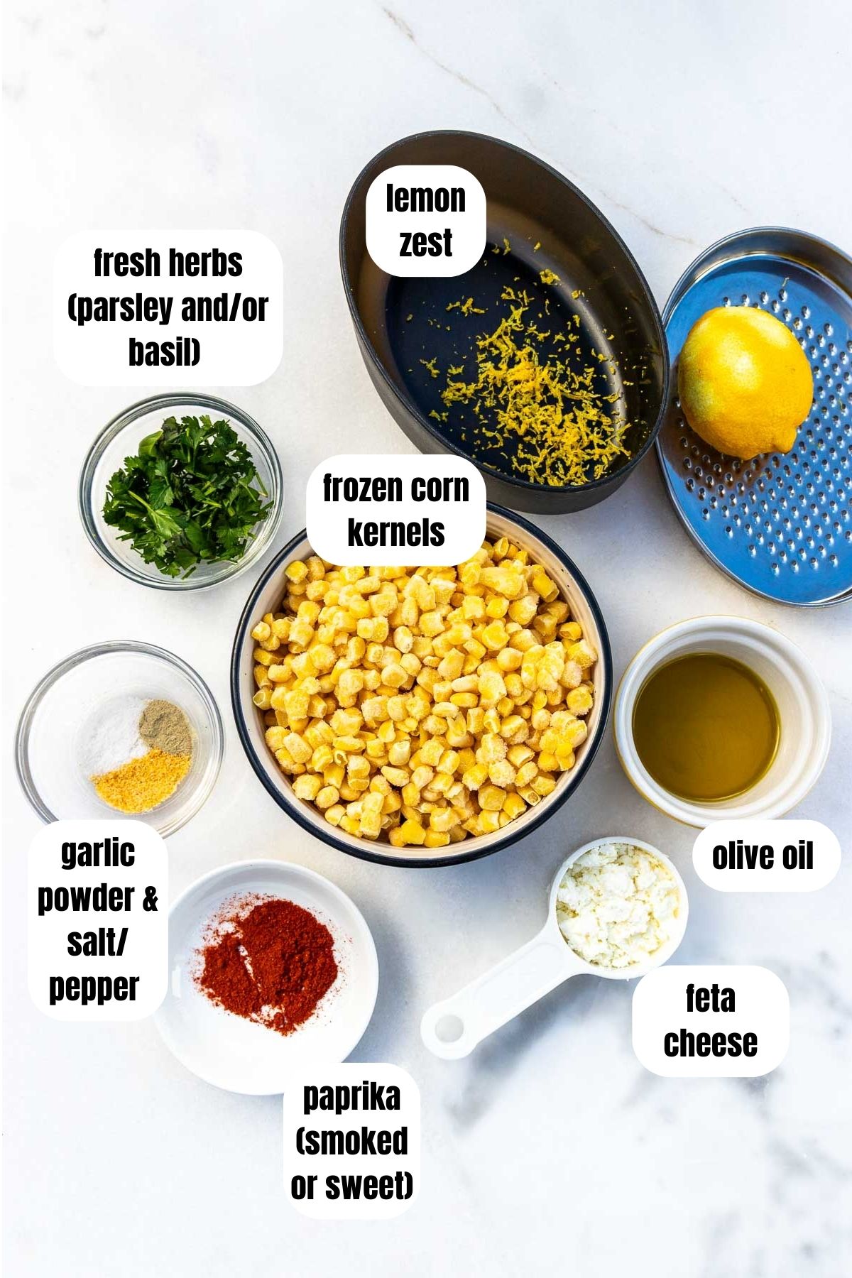 All the ingredients needed to make sauteed frozen corn including frozen corn, paprika, feta, garlic powder, salt and pepper, olive oil, lemon zest and fresh herbs.