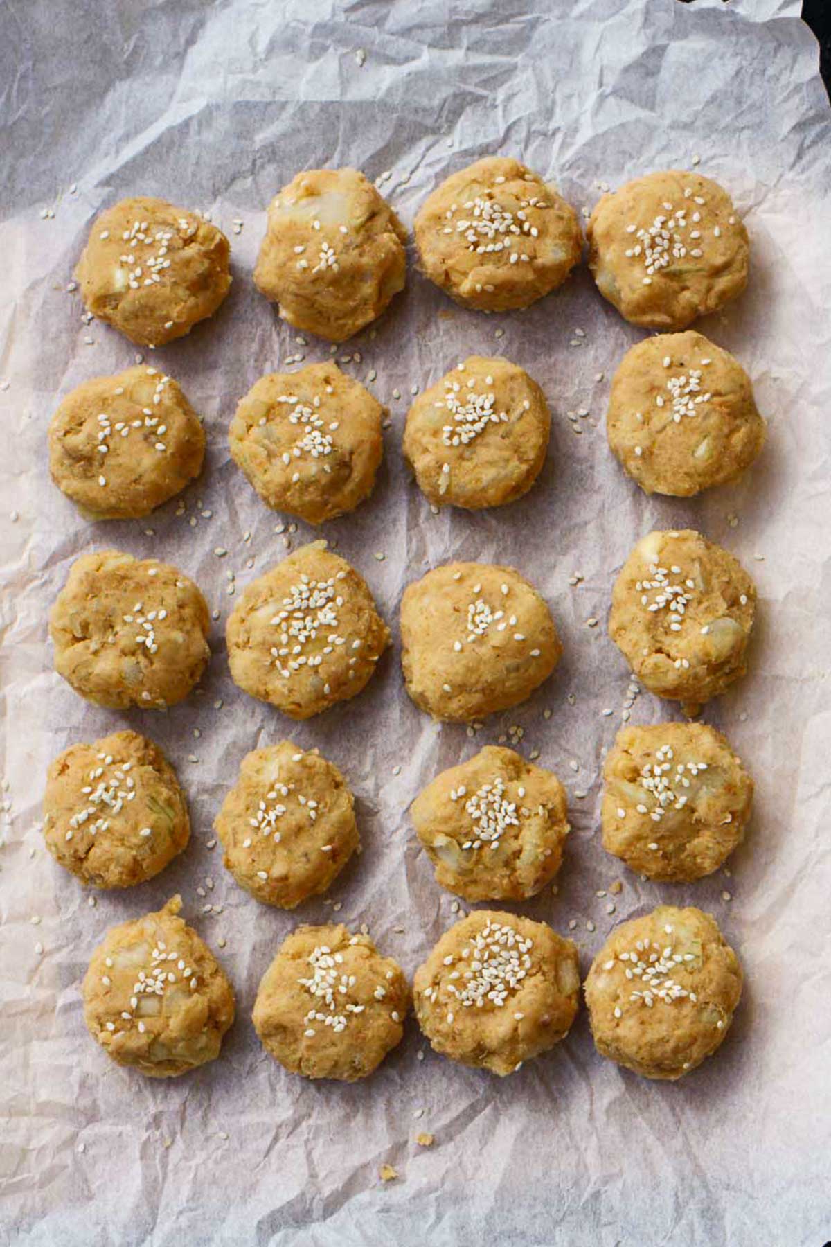 Overhead view of small sweet potato falafel patties with sesame seeds on top, ready to be cooked.